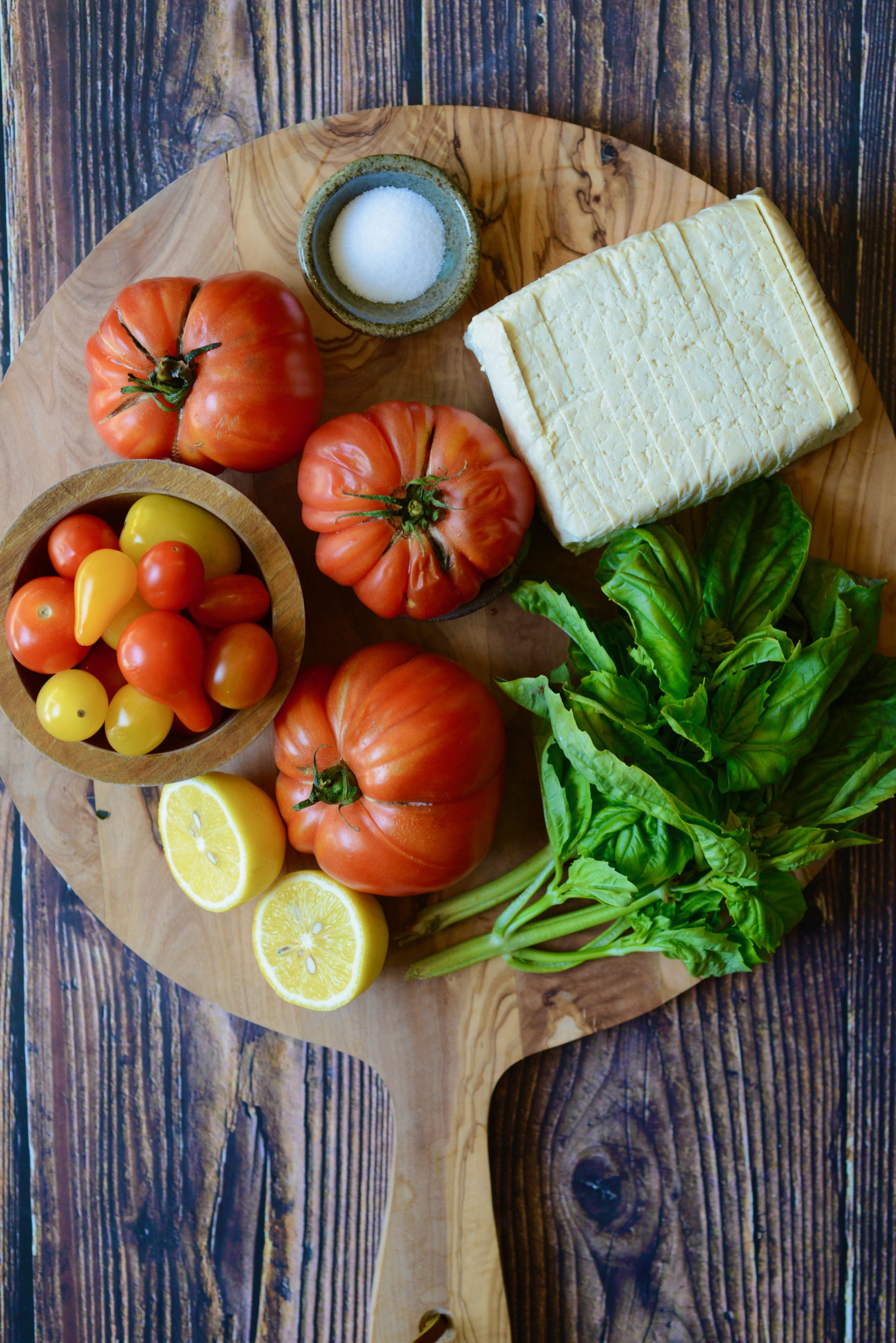 Ingredients for Vegan Caprese Salad - tomatoes (mix of large and small), super-firm tofu, salt, lemon, and fresh basil
