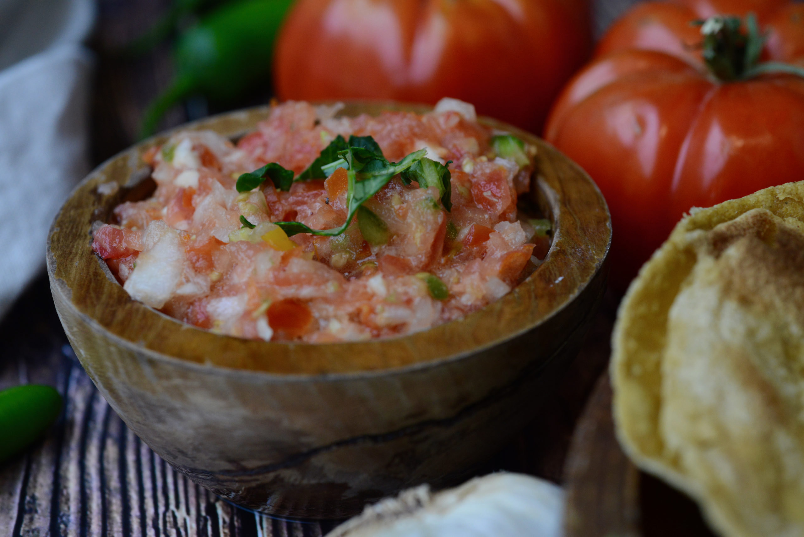 Pico de Gallo [Fresh Raw Salsa] surrounded by tomatoes, garlic, and toasted tortillas