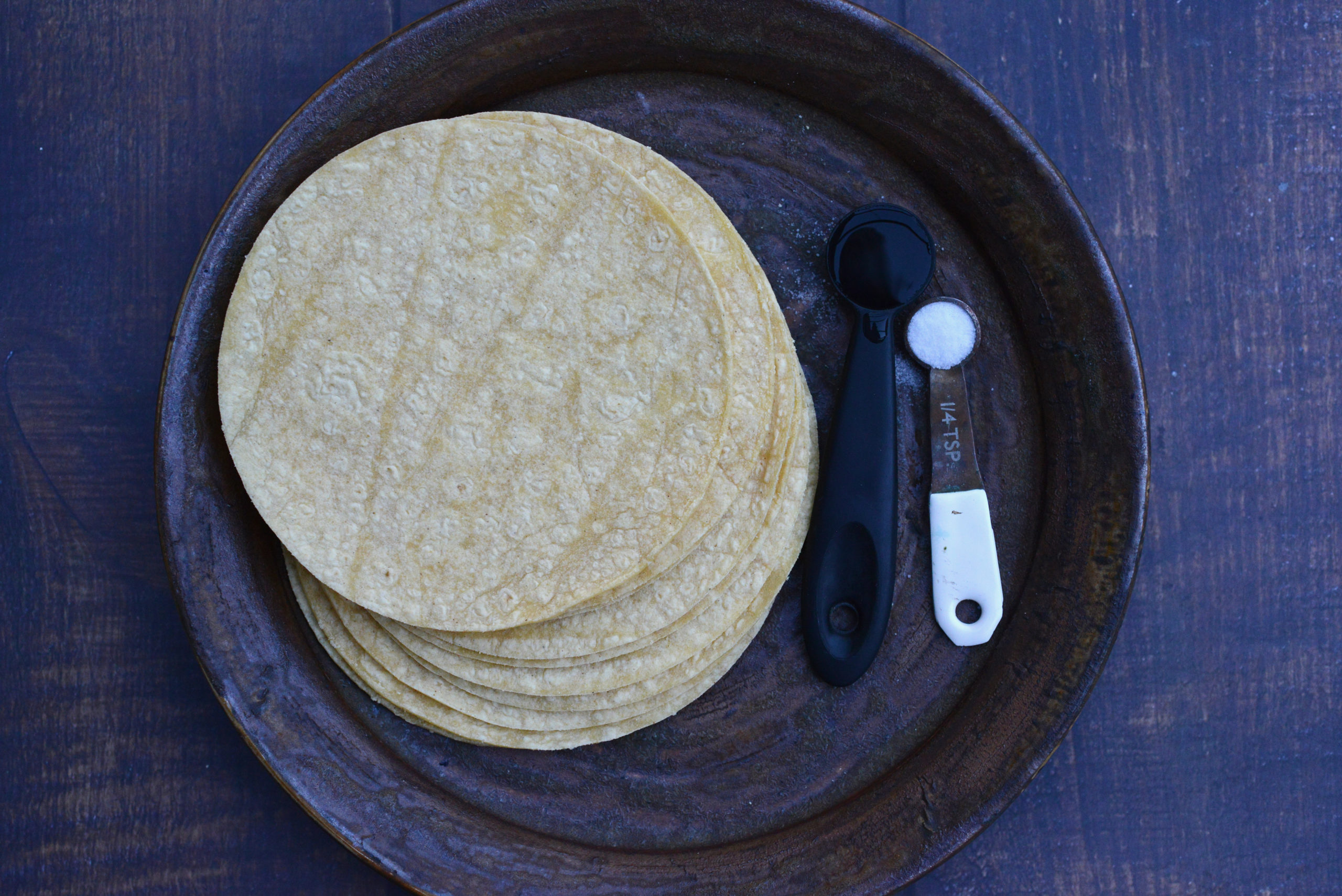 areal view of stack of corn tortillas with salt and water on a plate